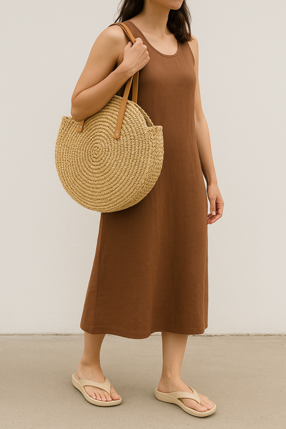 Femme portant un sac rond en paille 